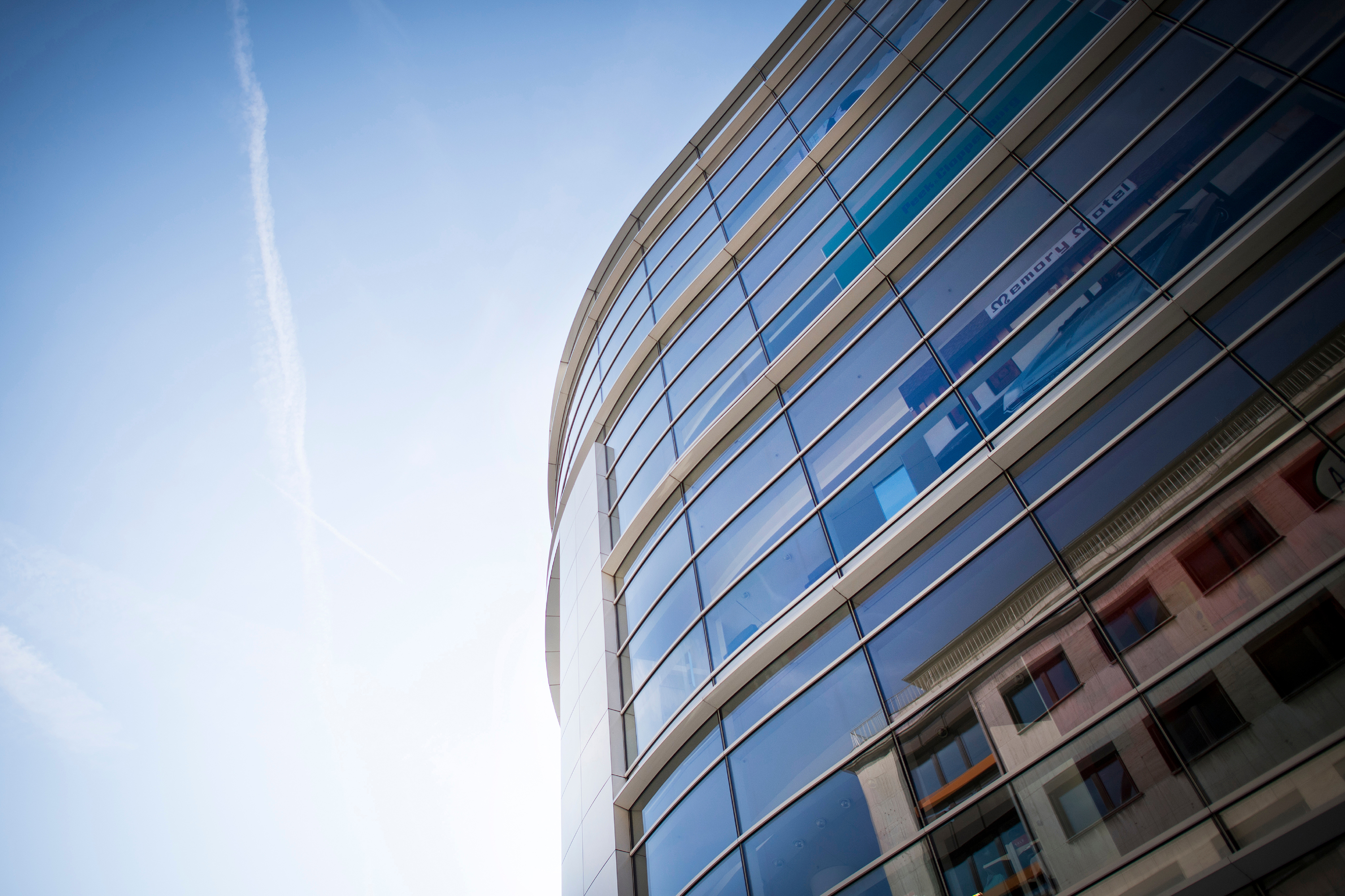 Blick von unten auf die Fassade eines modernen, verglasten P&C Verkaufshauses.